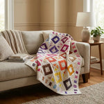 Handmade lap quilt shown draped on a sofa in a neutral living room.