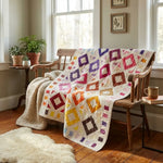 Handmade lap quilt shown on a wooden bench in a farmhouse-style room.
