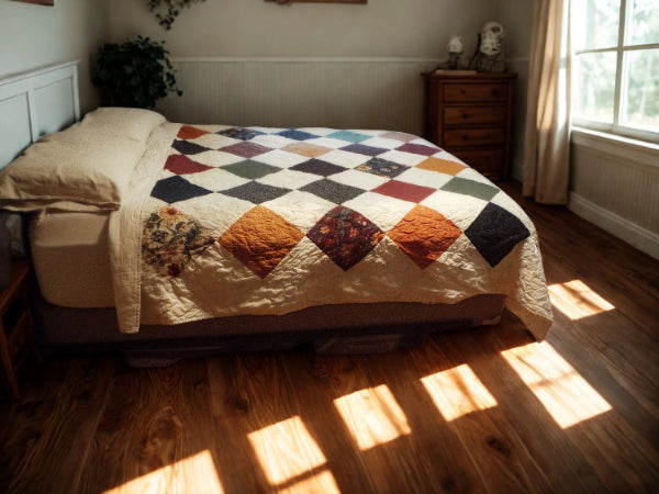 Close-up of handmade patchwork quilt featuring gold, plum, and forest green floral prints.