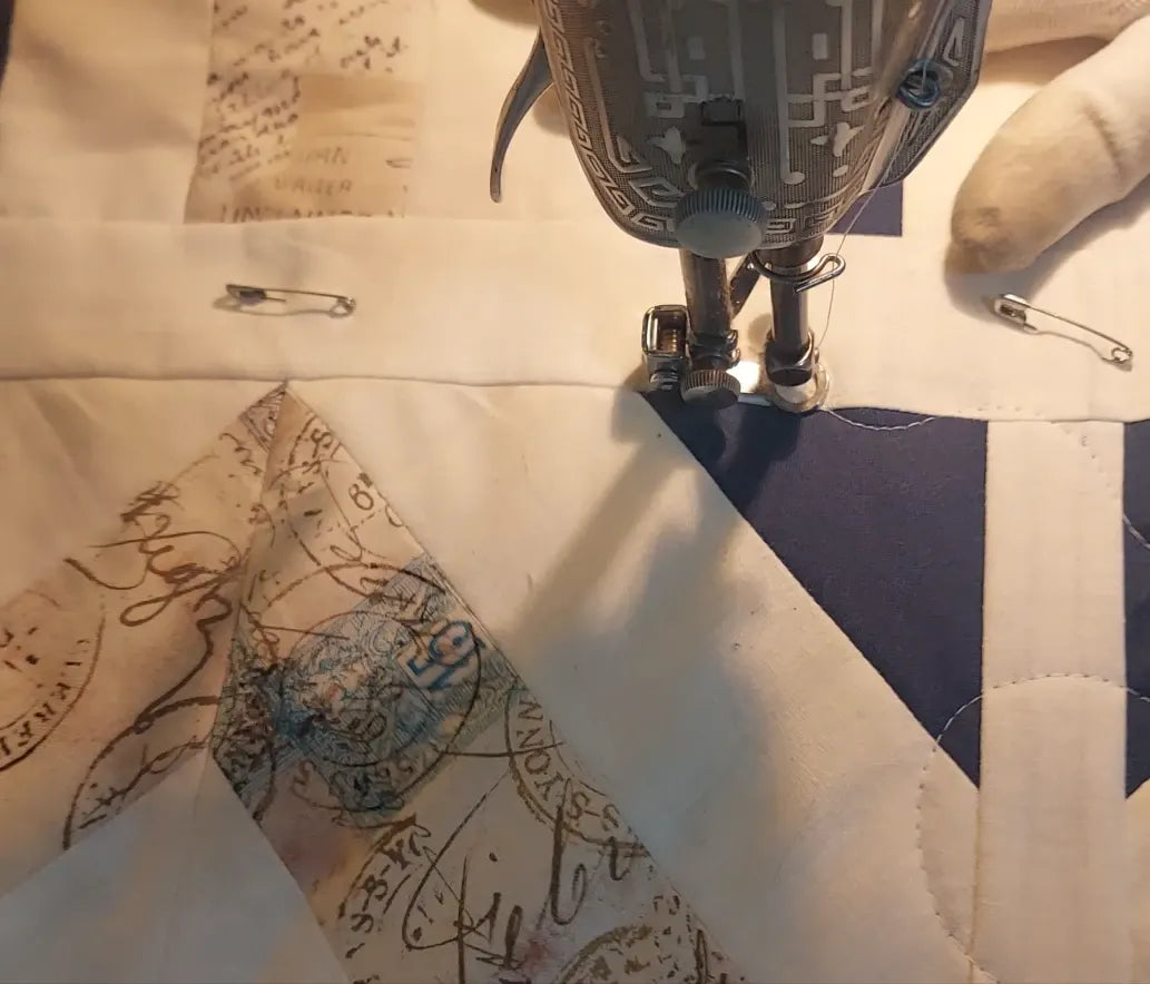 Close-up of a sewing machine needle stitching fabric with intricate patterns.