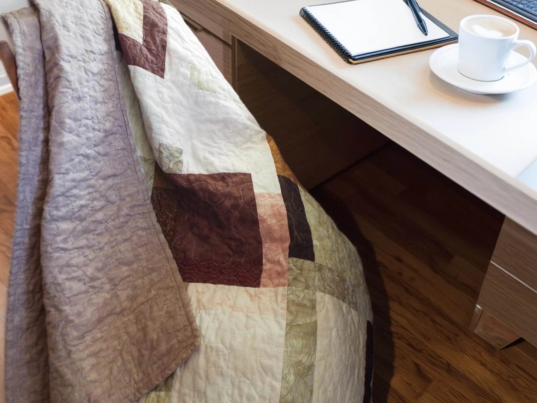 Handmade rose-gold quilt shown draped over a chair at a desk