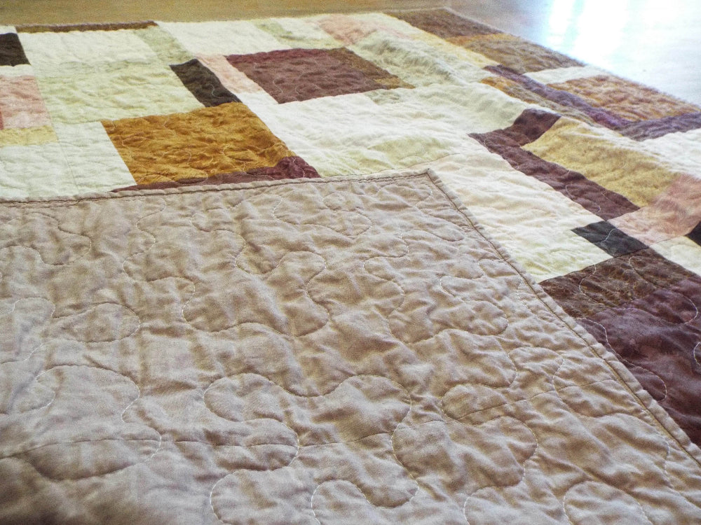 Handmade rose gold throw shown with backing flipped up to show stitching