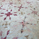 Angled lay of Scarlet Correspondence Queen Quilt showing more detail of design and stitching.