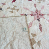 Corner flipped showing the backing of Scarlet Correspondence Queen Quilt.