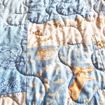Close-up of bunny fabric and free-motion quilting on handmade blue baby quilt