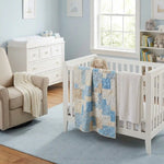 Quilt shown draped over a crib in a blue nursery