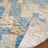 Quilt shown with corner flipped up to show the backing and stitching detail