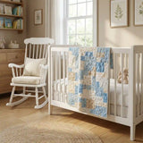 Baby quilt shown draped over a crib in a neutral nursery