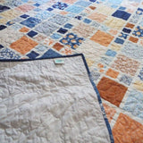Softspoken Summer King quilt shown with corner flipped up for backing and stitching detail.