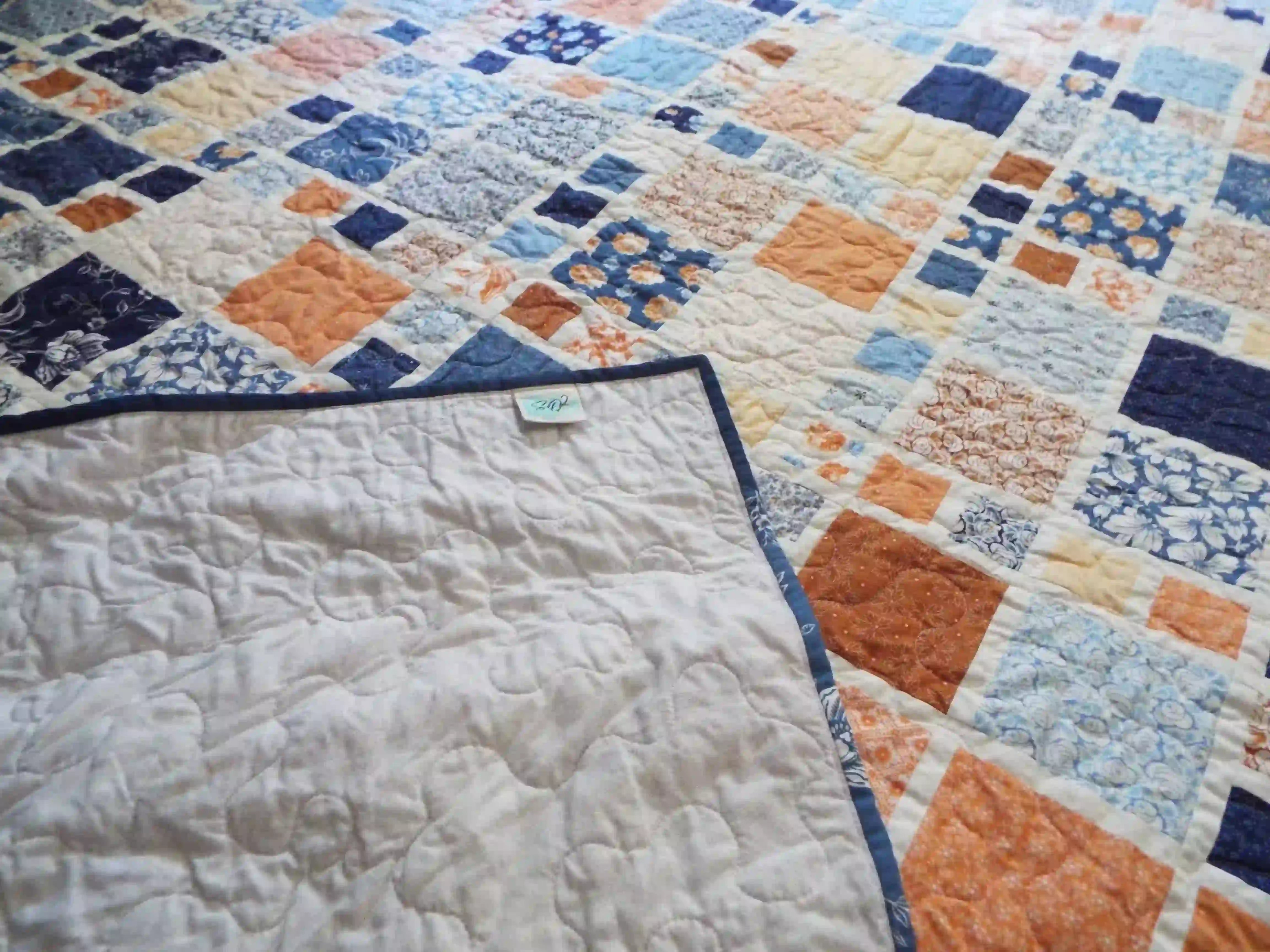 Softspoken Summer King quilt shown with corner flipped up for backing and stitching detail.