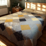 Quilt draped on queen bed with wood frame, showing classic patchwork pattern in calming blue tones.