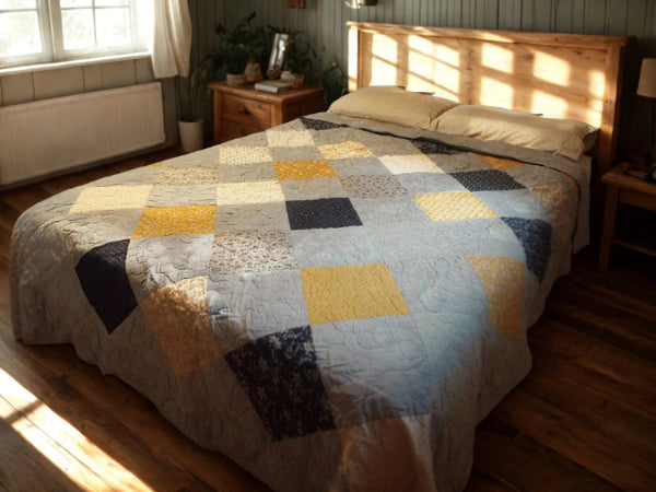Quilt draped on queen bed with wood frame, showing classic patchwork pattern in calming blue tones.