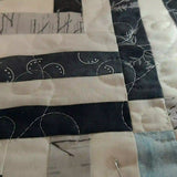 Detail image showing quilting in progress of handmade black and white twin quilt