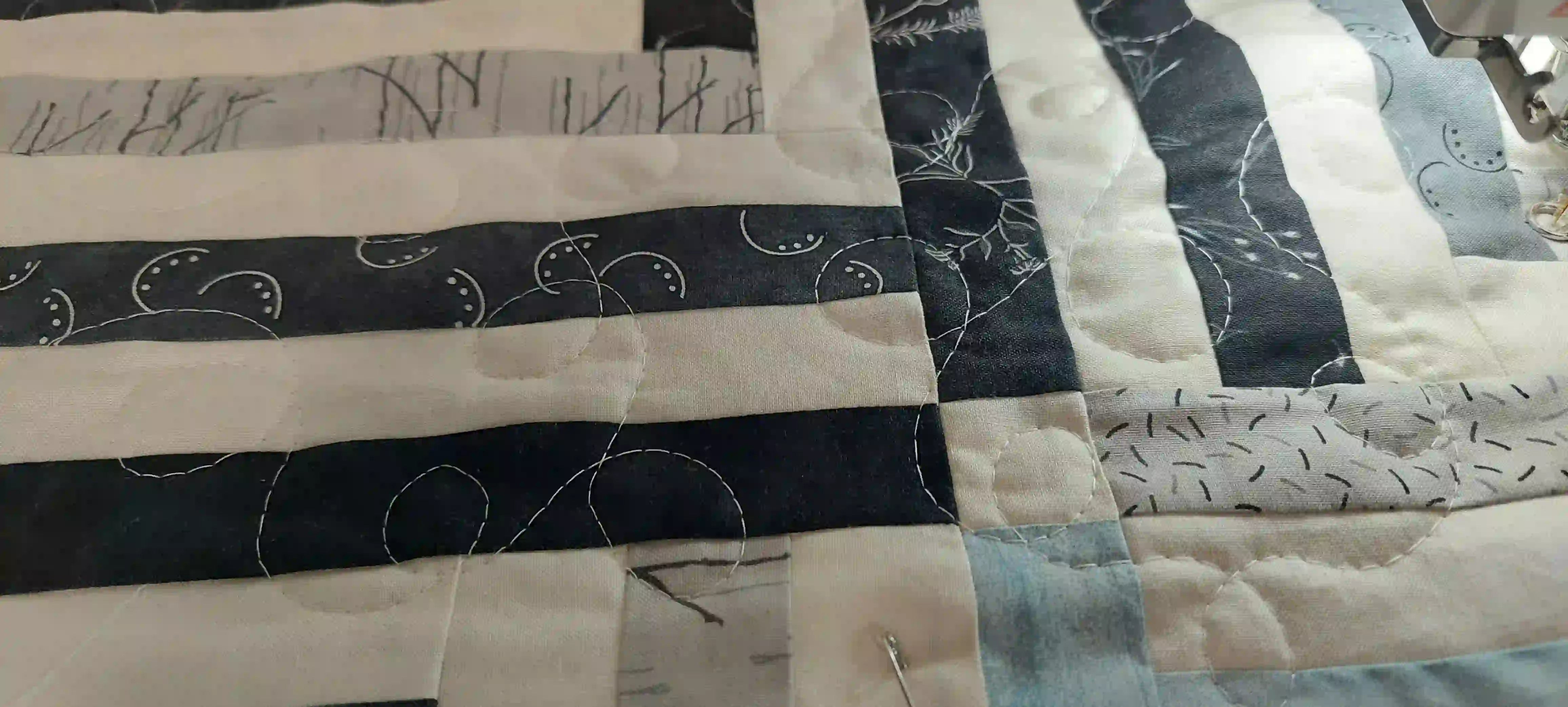 Detail image showing quilting in progress of handmade black and white twin quilt