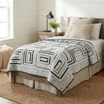 Handmade twin quilt in black and white with blue accents styled in a modern farmhouse bedroom