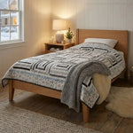 Handmade twin quilt styled in modern minimal bedroom on twin size bed.