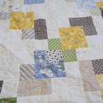 Detail shot of the handmade quilt showing stitching, piecing, and quilt texture