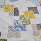 Detail shot of the handmade quilt showing stitching, piecing, and quilt texture