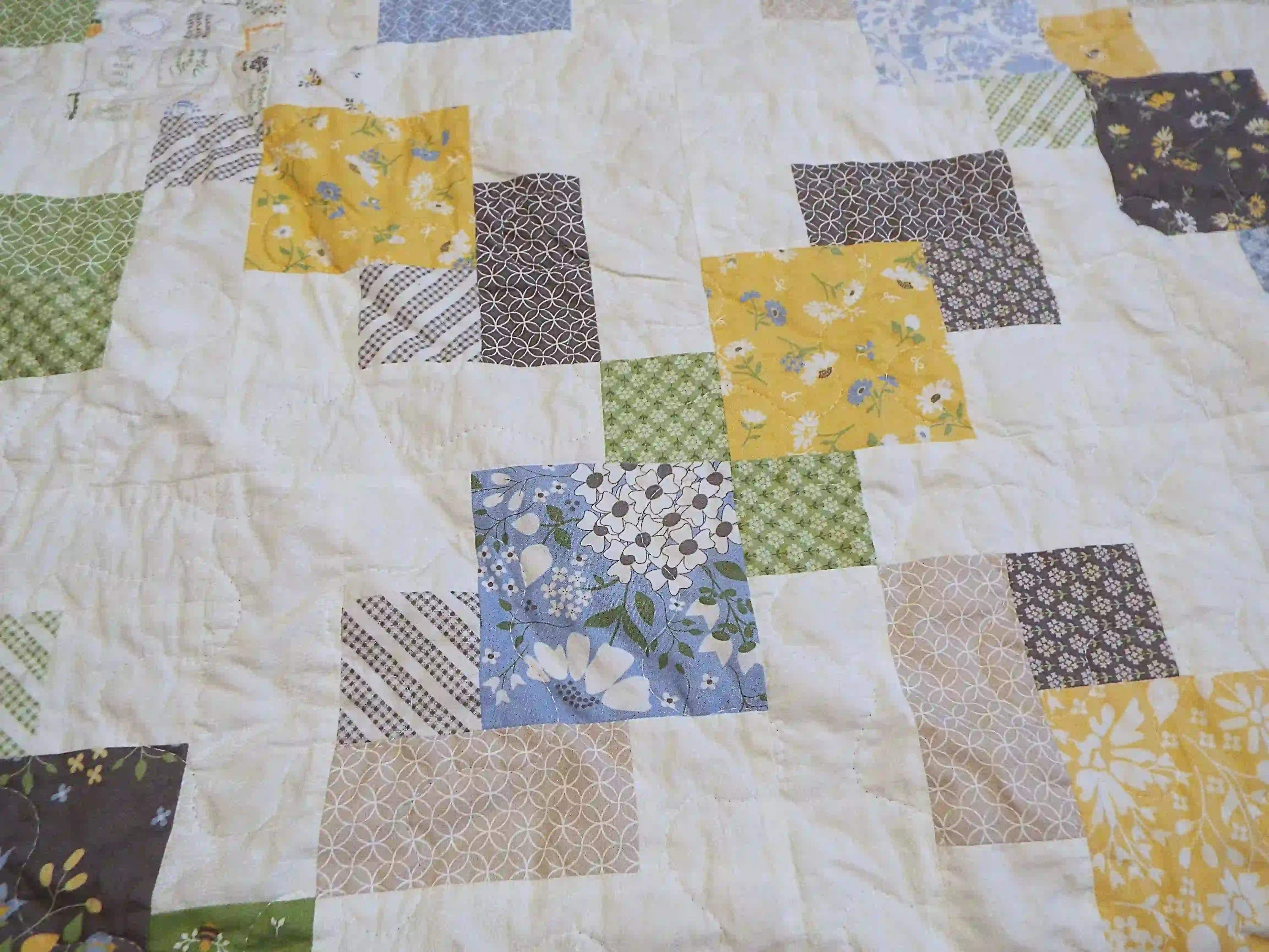 Detail shot of the handmade quilt showing stitching, piecing, and quilt texture