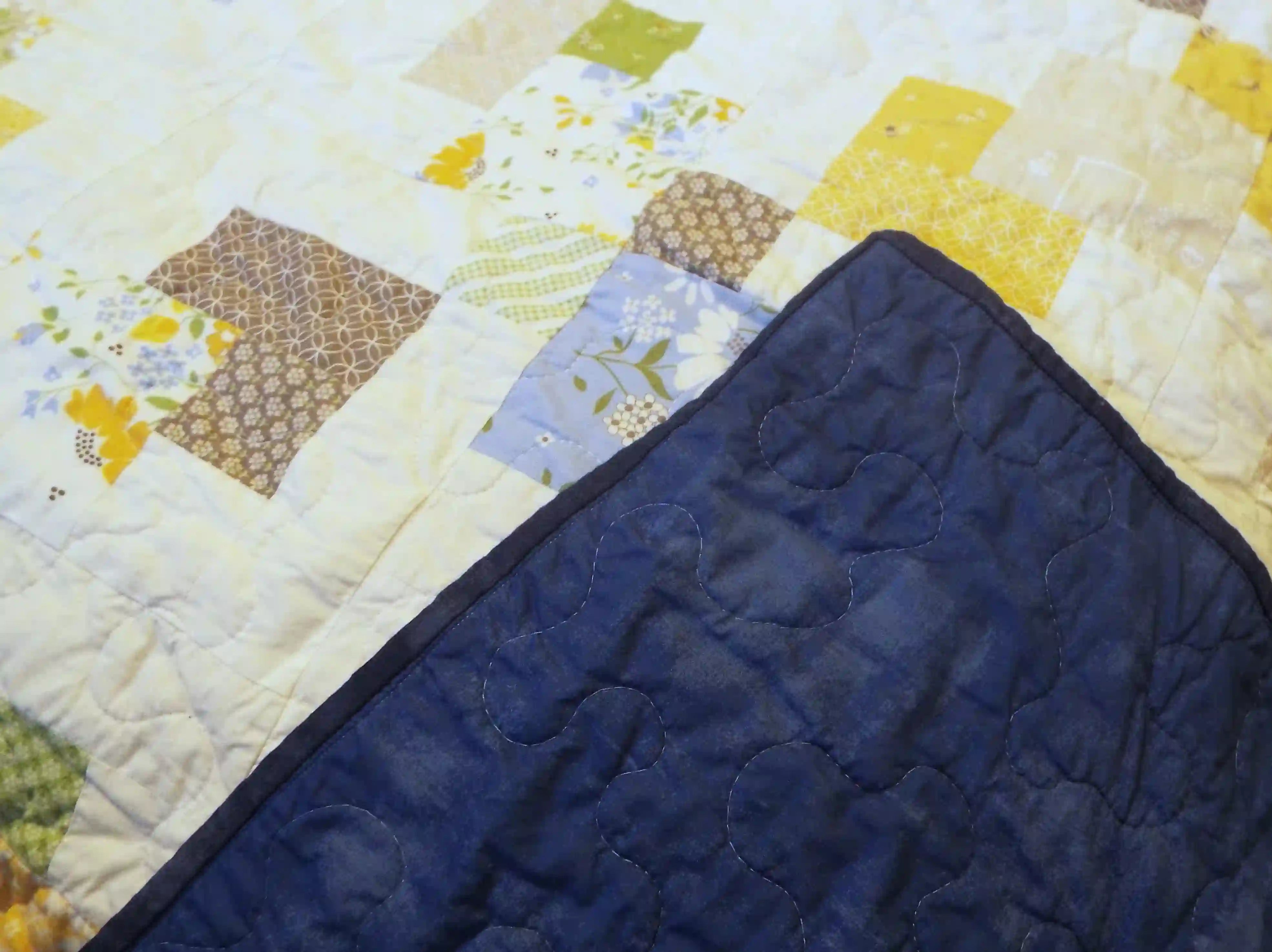 Handmade quilt with corner flipped to show backing with quilt top