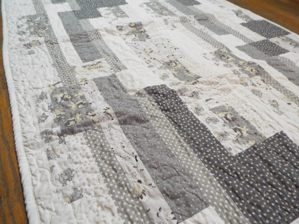 Angled flat lay of Starlit Trails gray baby quilt
