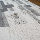 Corner flipped to show backing on Starlit Trails gray baby quilt