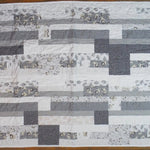 Flat lay of Starlit Trails gray baby quilt