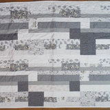 Flat lay of Starlit Trails gray baby quilt