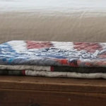 Army Eagle tribute quilt folded on top of a wooden trunk