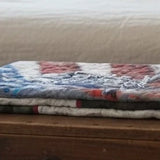 Army Eagle tribute quilt folded on top of a wooden trunk