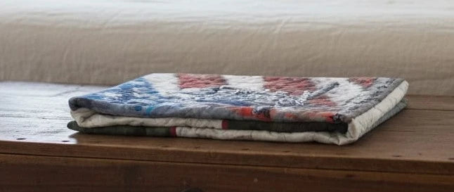 Army Eagle tribute quilt folded on top of a wooden trunk