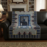 Tribute quilt shown draped over a black leather sofa in a traditional living room.