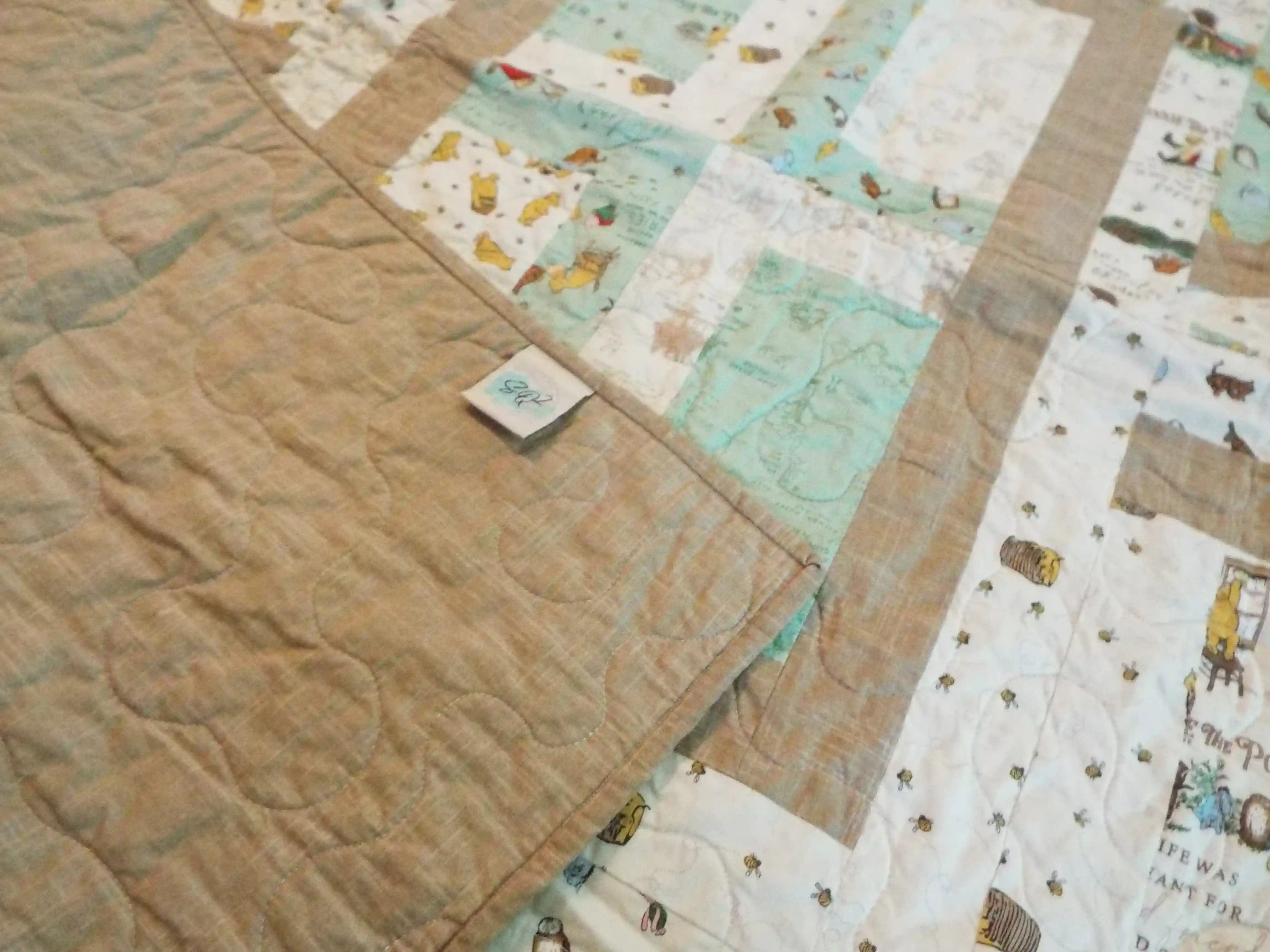 Corner flipped up on Stories in the Woods Baby Quilt showing backing detail.
