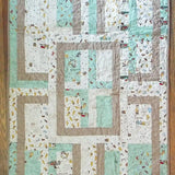 Flat lay of Stories in the Woods Baby Quilt showing entire quilt.