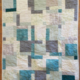 Flat lay of handmade teal and cream throw showing entire pattern