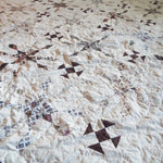 Angled lay of The Archivist Queen Quilt showing a closer look at the pattern and construction.