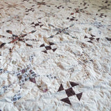 Angled lay of The Archivist Queen Quilt showing a closer look at the pattern and construction.