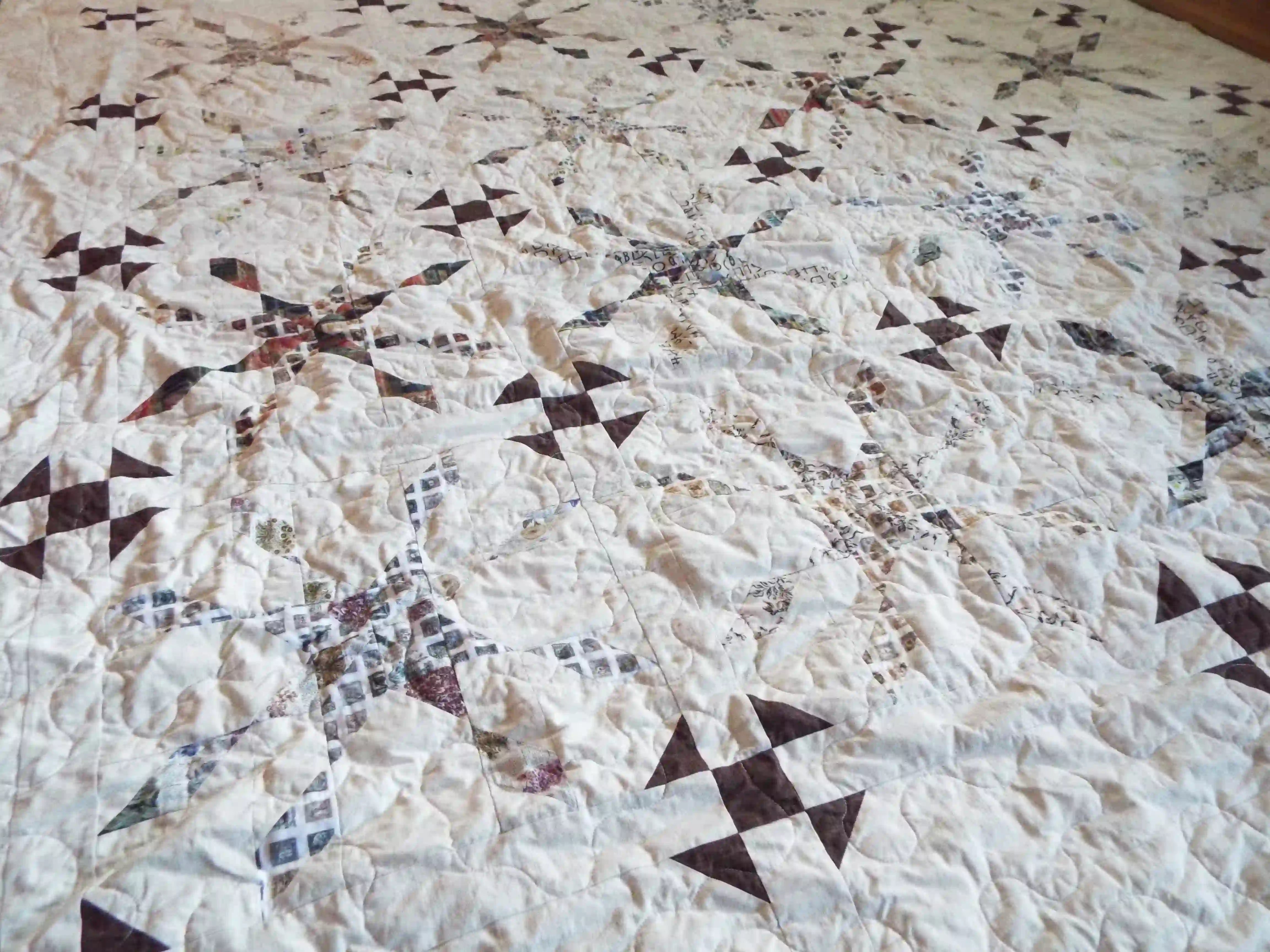 Angled lay of The Archivist Queen Quilt showing a closer look at the pattern and construction.