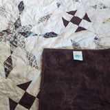 The Archivist Queen Quilt shown with the corner flipped over to show the backing.
