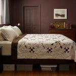The Archivist Queen Quilt styled on a dark wood bed in a bedroom with dark burgundy walls.