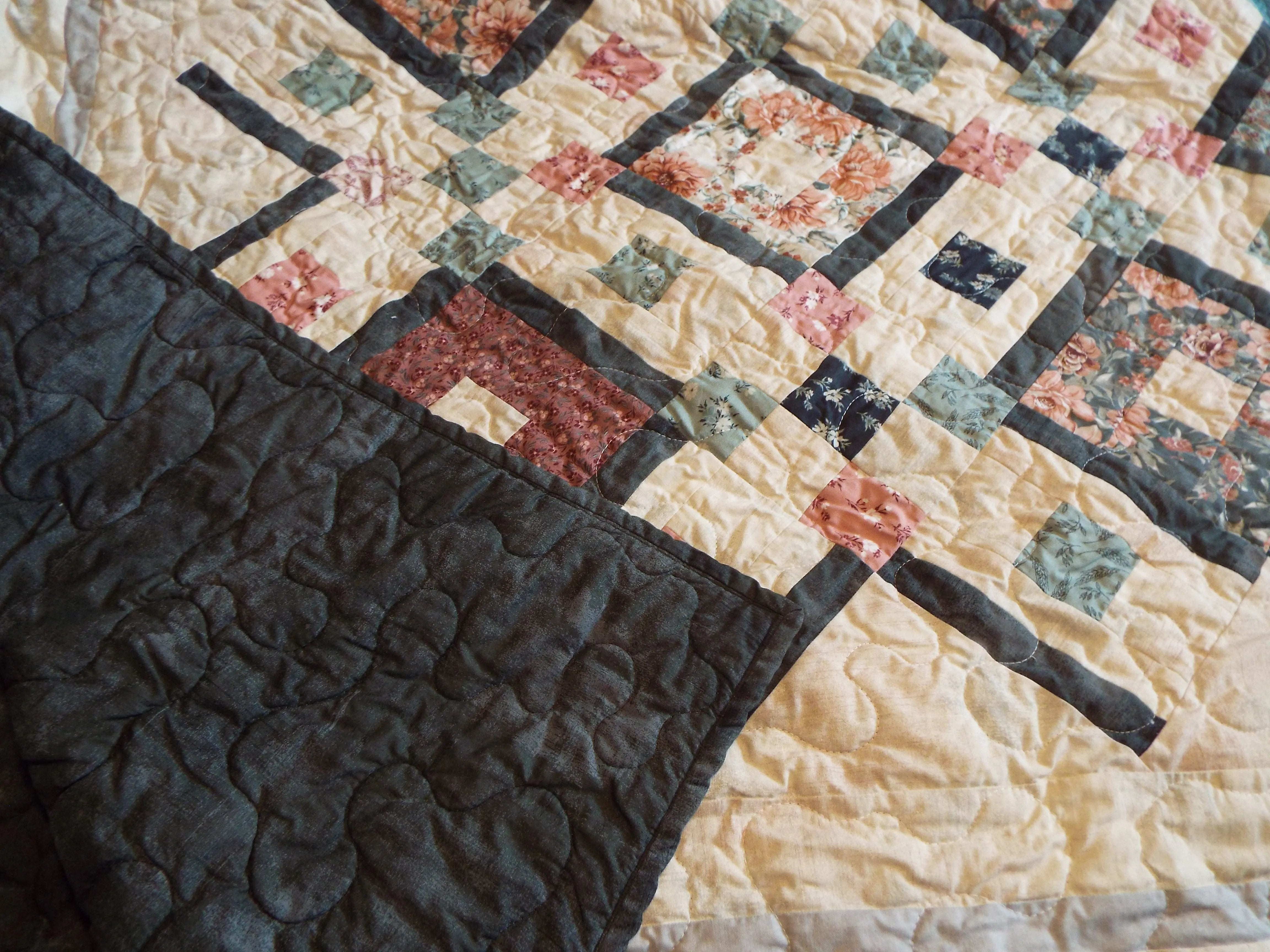 Detail of quilting and backing on twin handmade quilt in rose and green
