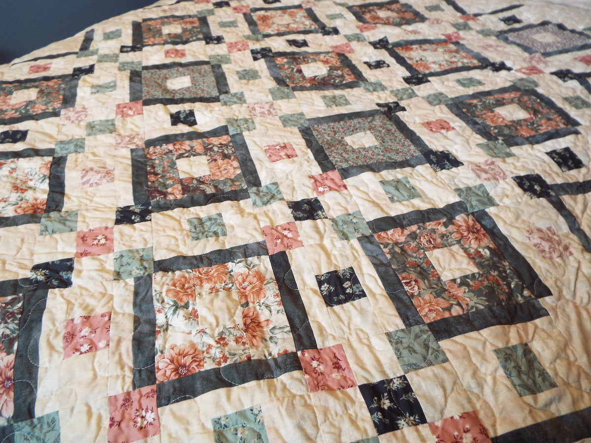 Close up of twin floral handmade quilt in rose and sage with charcoal accents