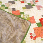 Corner flipped up to show the backing of quilt.