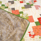 Corner flipped up to show the backing of quilt.