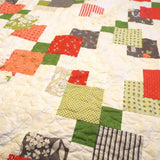 Close up of Vibrant Handmade Quilt showcasing fabrics and stitching.