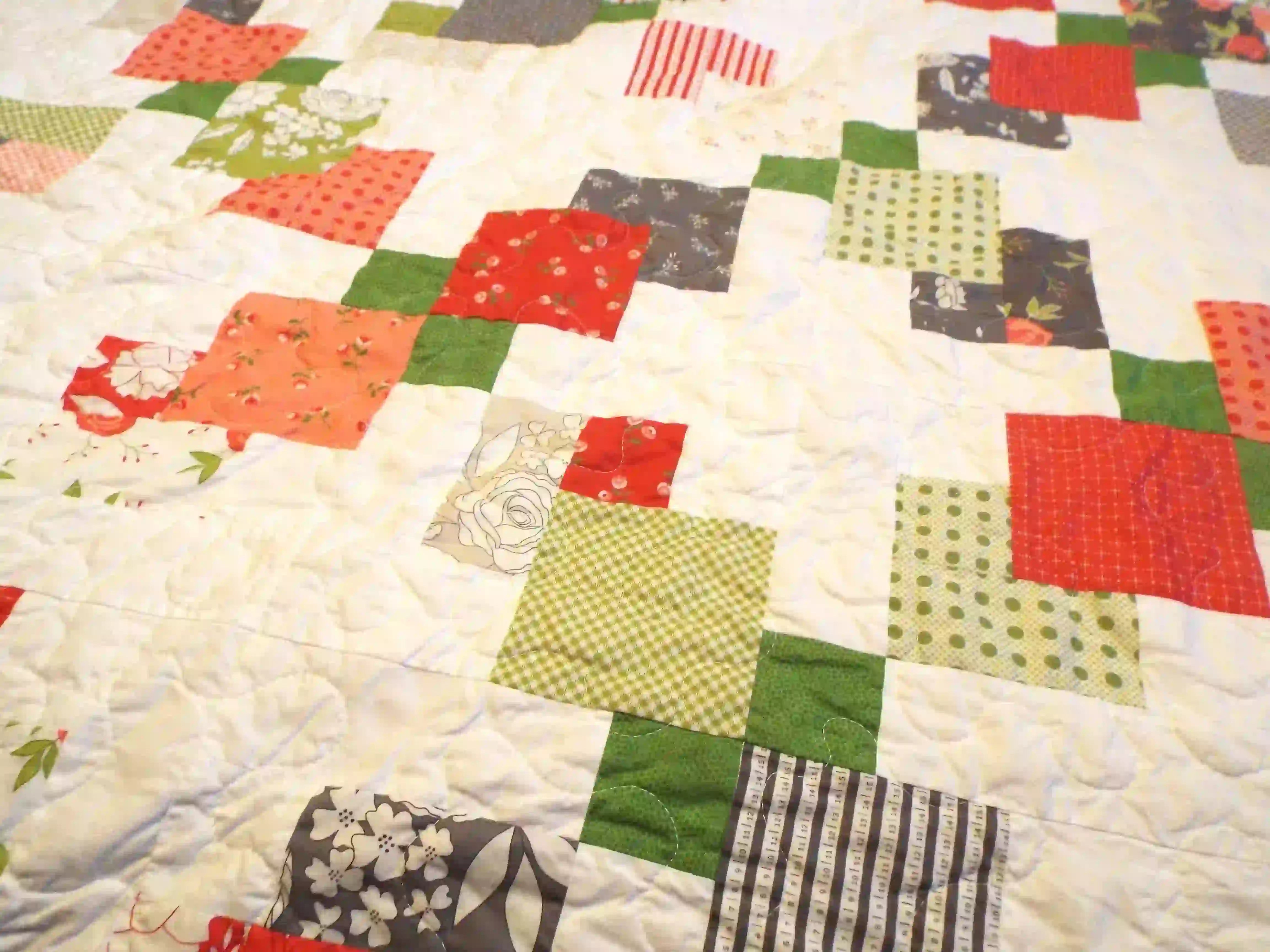Close up of Vibrant Handmade Quilt showcasing fabrics and stitching.