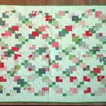 Flat lay of vibrant handmade twin quilt showing entire quilt