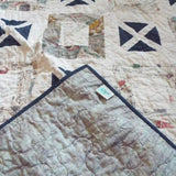Handmade lap quilt shown with corner flipped over to show backing