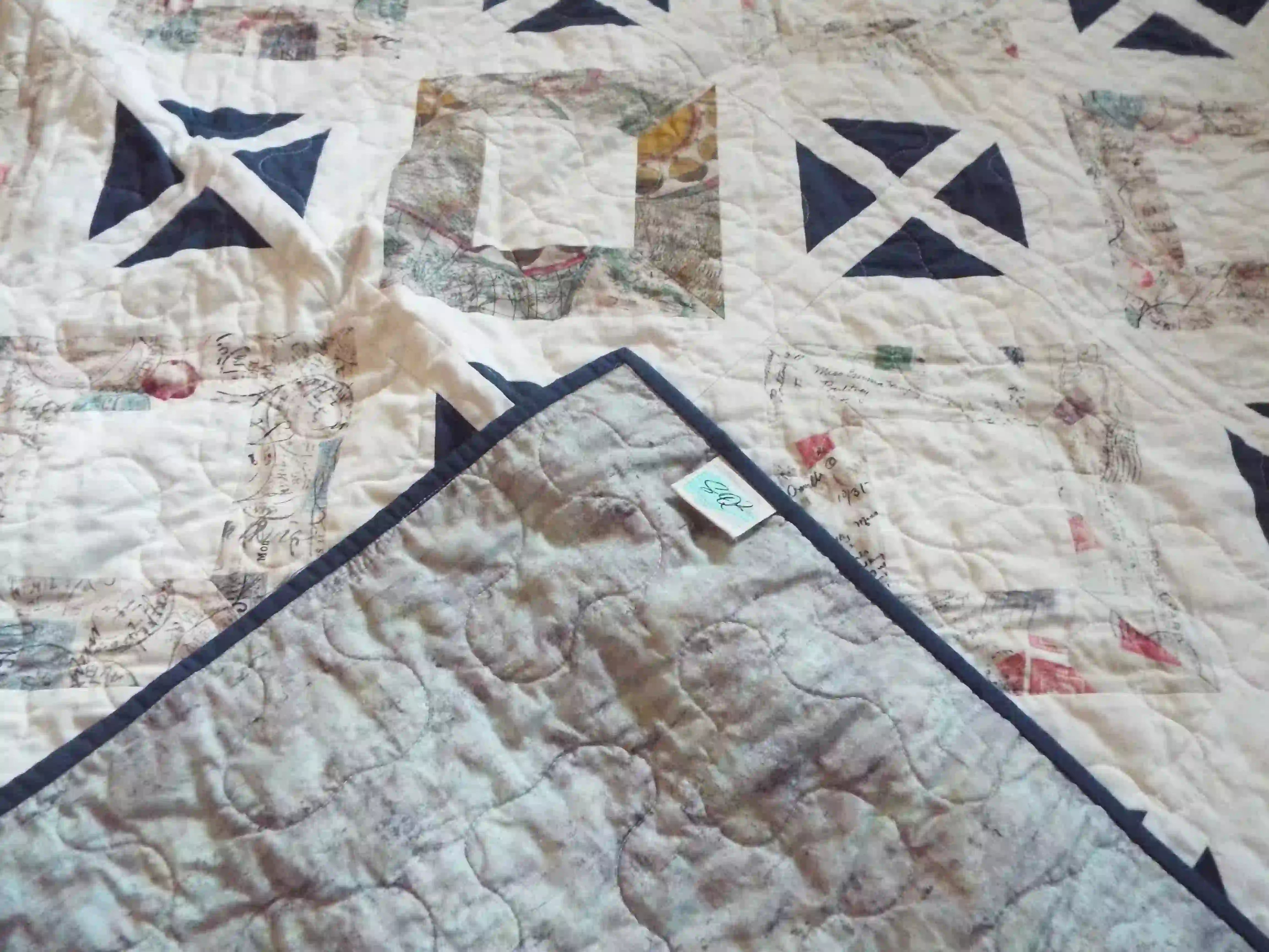 Handmade lap quilt shown with corner flipped over to show backing