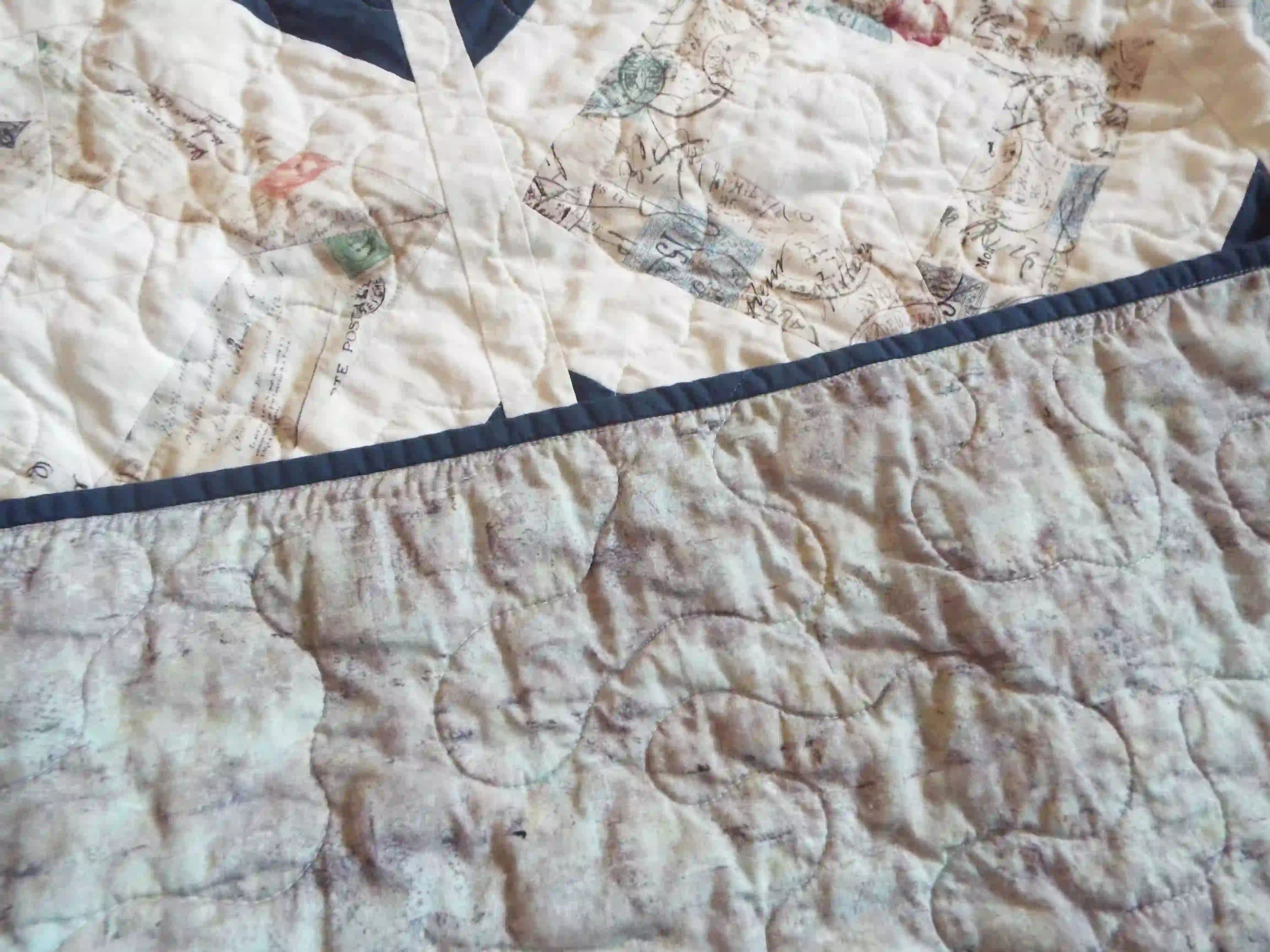 Detail shot showing backing, binding, and quilt top along with stitching